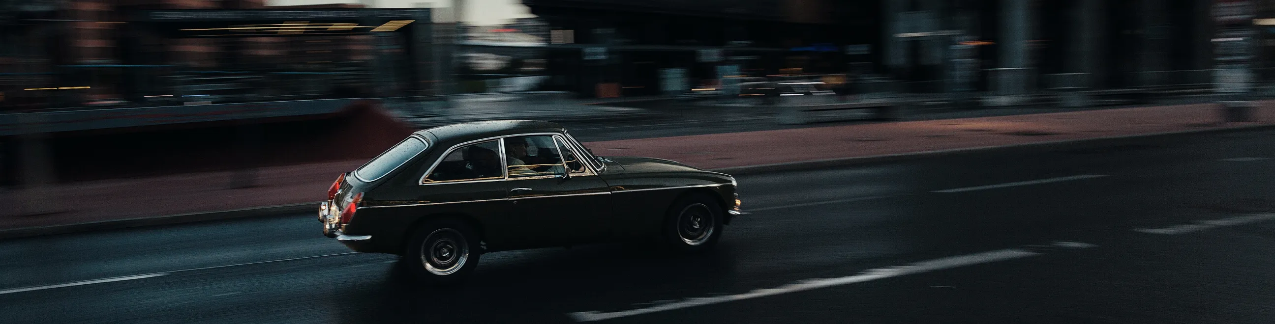 Klassisk svart bil på vei i mørket