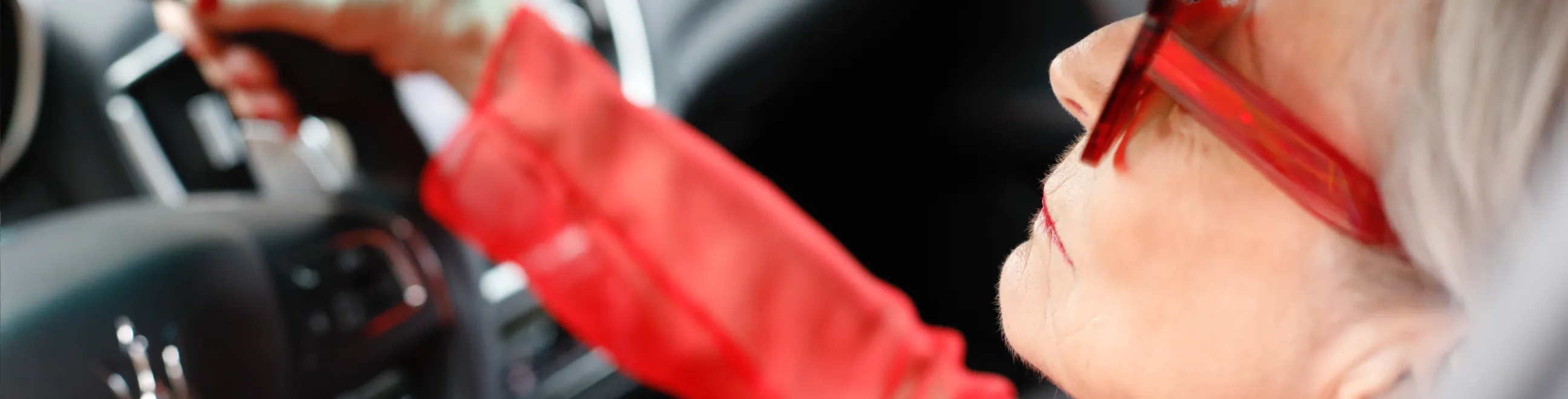 Kvinne i rødt kjører bil